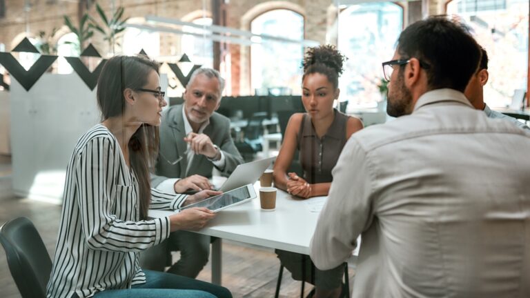 Using digital technologies. Young business woman holding digital tablet and discussing something